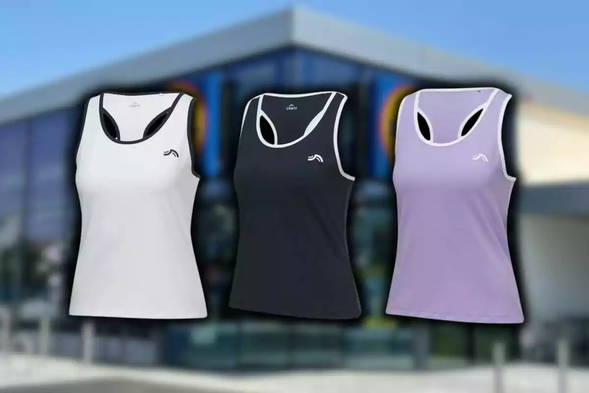 Tres camisetas deportivas sin mangas en colores blanco, negro y lila de Lidl frente a uno de sus supermercados. Tres camisetas deportivas sin mangas en colores blanco, negro y lila de Lidl frente a uno de sus supermercados.