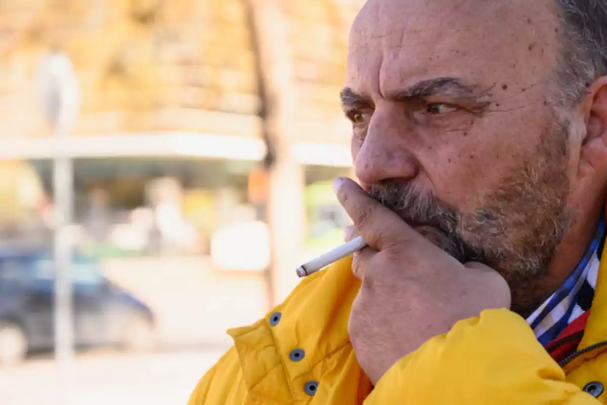 Manuel Padín fumando en la calle.