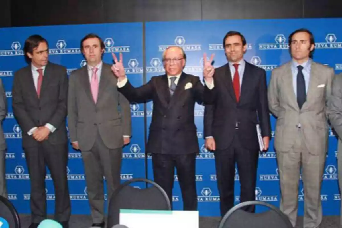 José María Ruiz-Mateos y algunos de sus hijos varones en un photocall. Ruiz-Mateos tiene los brazos en alto, haciendo el símbolo de la victoria con los dedos.