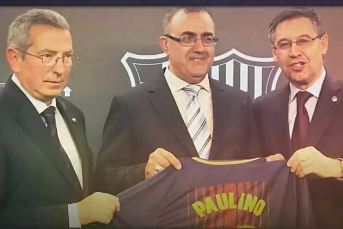 Tres hombres en traje sosteniendo una camiseta de fútbol con el nombre Tres hombres en traje sosteniendo una camiseta de fútbol con el nombre