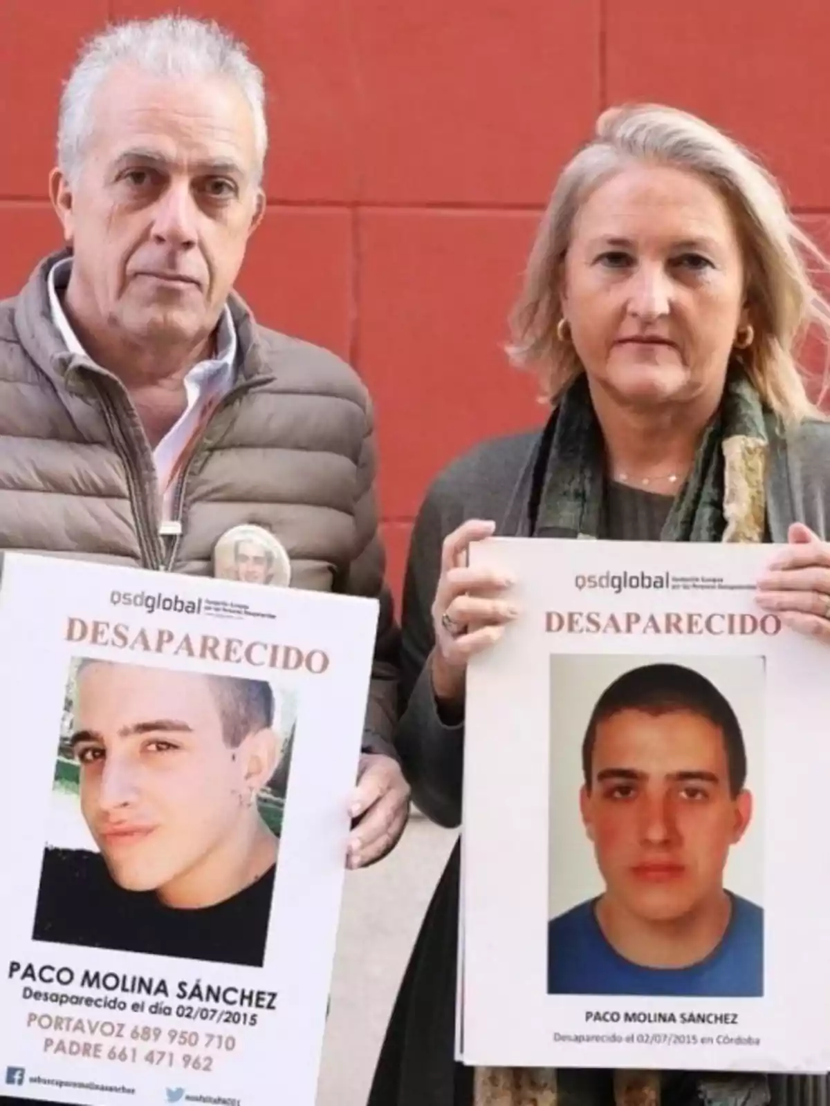 Dos personas sostienen carteles de búsqueda de un joven desaparecido llamado Paco Molina Sánchez.