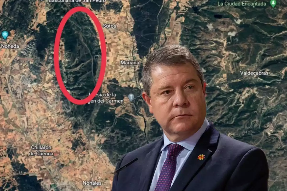 Un hombre con traje y corbata aparece frente a un mapa satelital que muestra una región con nombres de localidades y un área marcada con un óvalo rojo.