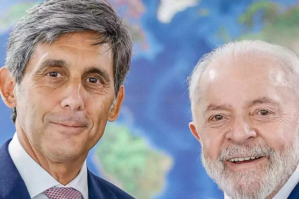 Dos hombres posando frente a un mapa del mundo.