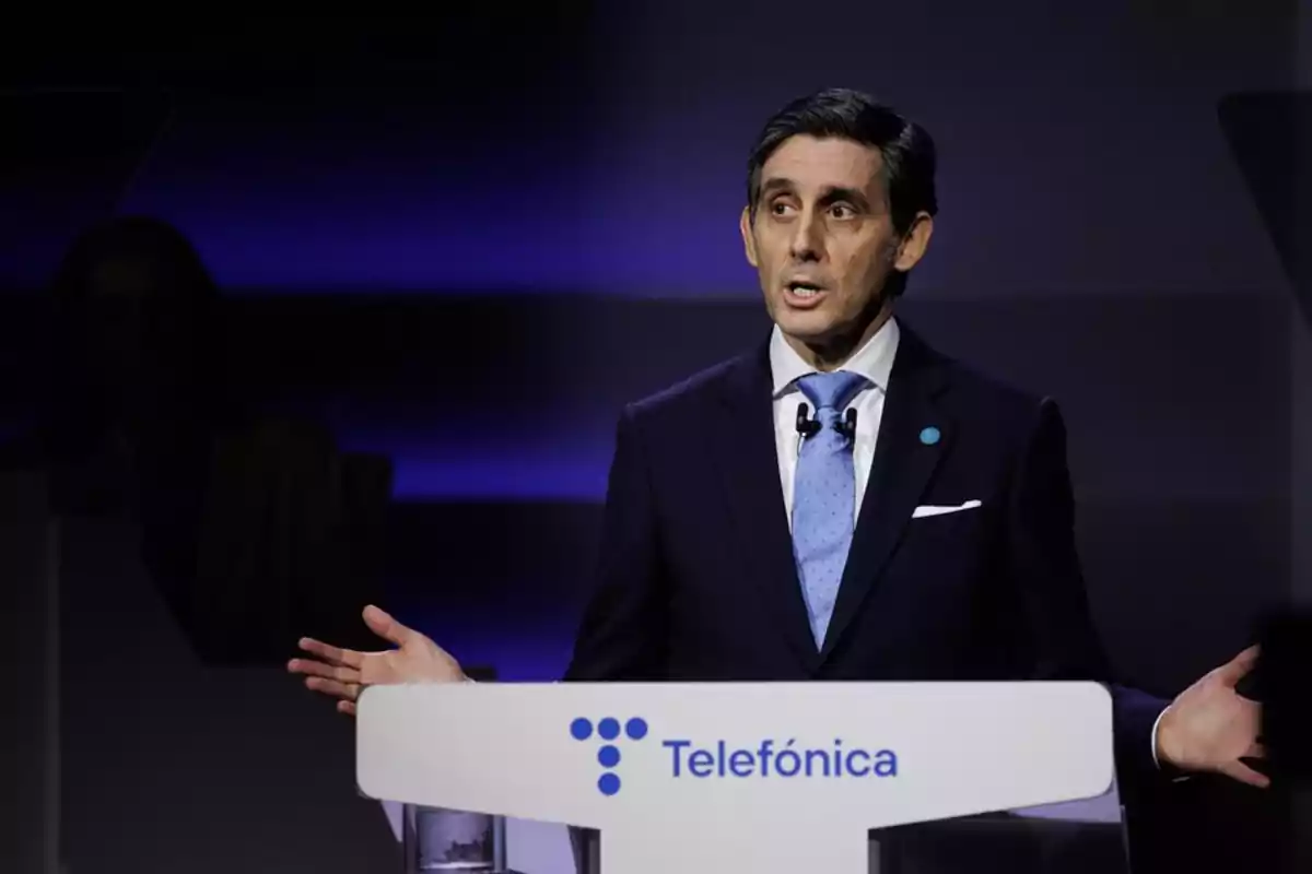 Hombre de traje y corbata hablando en un podio con el logo de Telefónica.