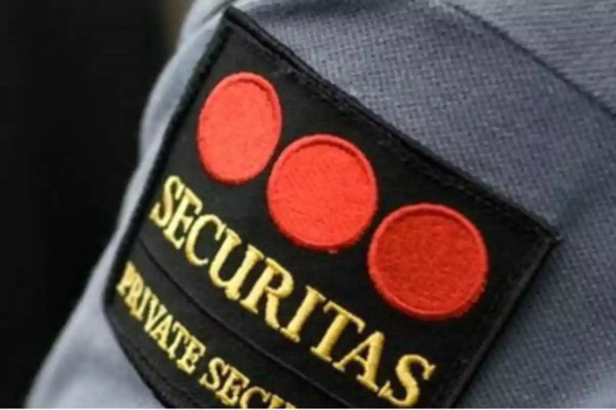 Insignia de seguridad privada con tres círculos rojos y el texto 