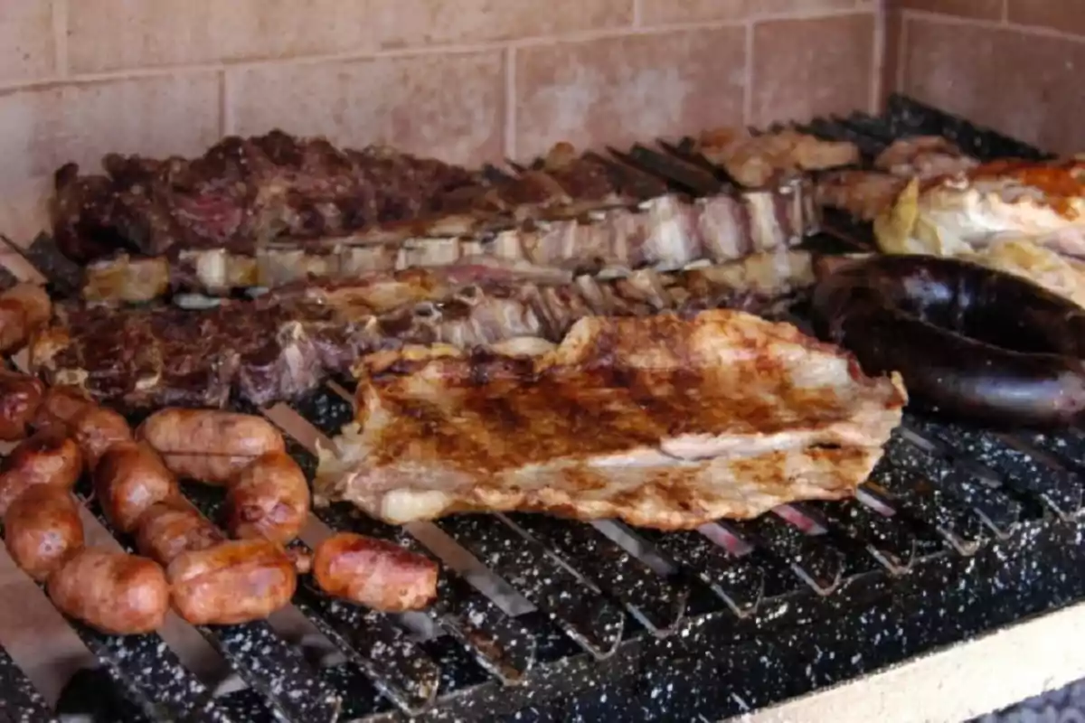 Una parrilla llena de diferentes tipos de carne asándose.