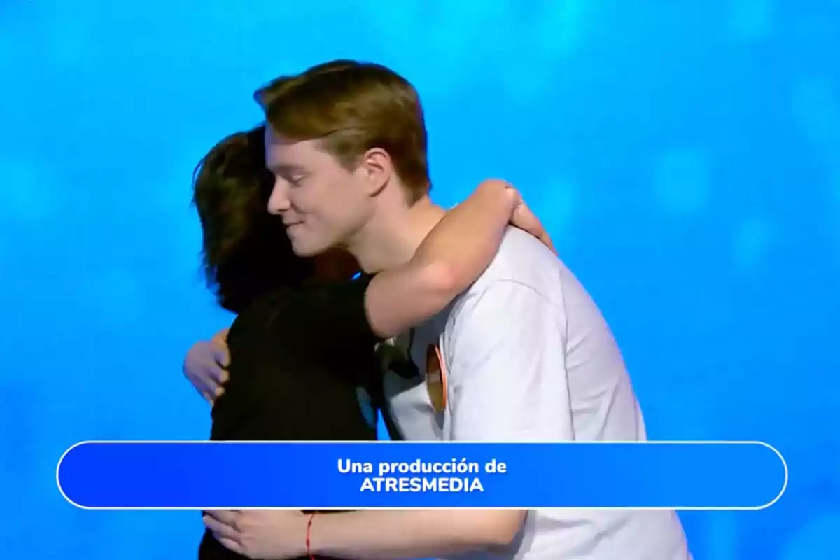 Rosa y Manu se abrazan frente a un fondo azul con un recuadro en la parte inferior que dice una producción de ATRESMEDIA. Captura de 'Pasapalabra' Rosa y Manu se abrazan frente a un fondo azul con un recuadro en la parte inferior que dice una producción de ATRESMEDIA. Captura de 'Pasapalabra'