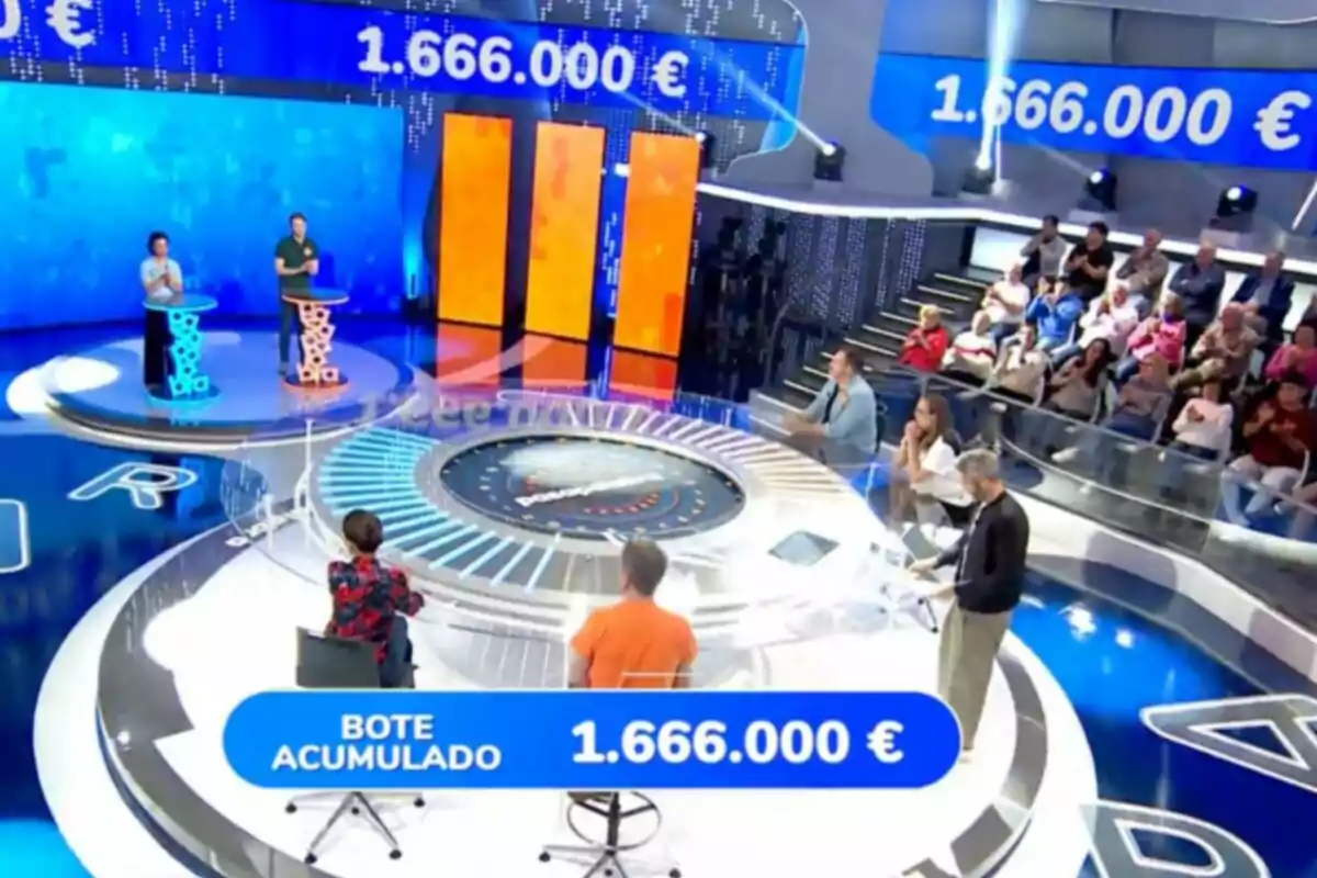 Un plató de concurso televisivo con concursantes, presentador, público y un bote acumulado de 1.666.000 euros mostrado en pantalla. Captura de 'Pasapalabra' Un plató de concurso televisivo con concursantes, presentador, público y un bote acumulado de 1.666.000 euros mostrado en pantalla. Captura de 'Pasapalabra'