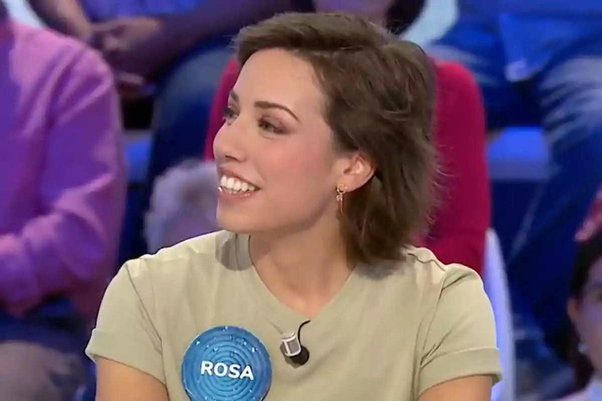 Rosa con camiseta clara sonríe mientras participa en un programa de televisión, lleva un pin azul con el nombre Rosa. Captura de 'Pasapalabra' Rosa con camiseta clara sonríe mientras participa en un programa de televisión, lleva un pin azul con el nombre Rosa. Captura de 'Pasapalabra'