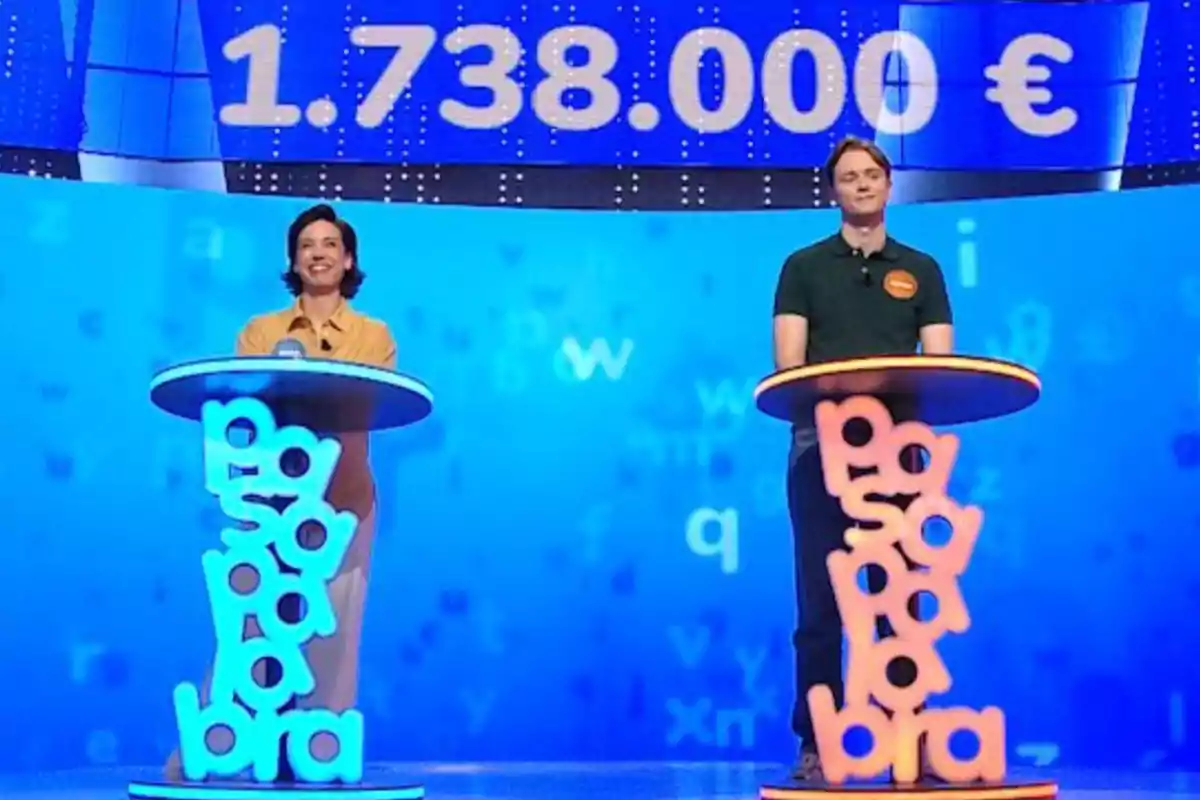 Rosa y Manu de pie en un plató de televisión con decorado azul y la cifra 1.738.000 euros en grande sobre ellos. Captura de 'Pasapalabra' Rosa y Manu de pie en un plató de televisión con decorado azul y la cifra 1.738.000 euros en grande sobre ellos. Captura de 'Pasapalabra'
