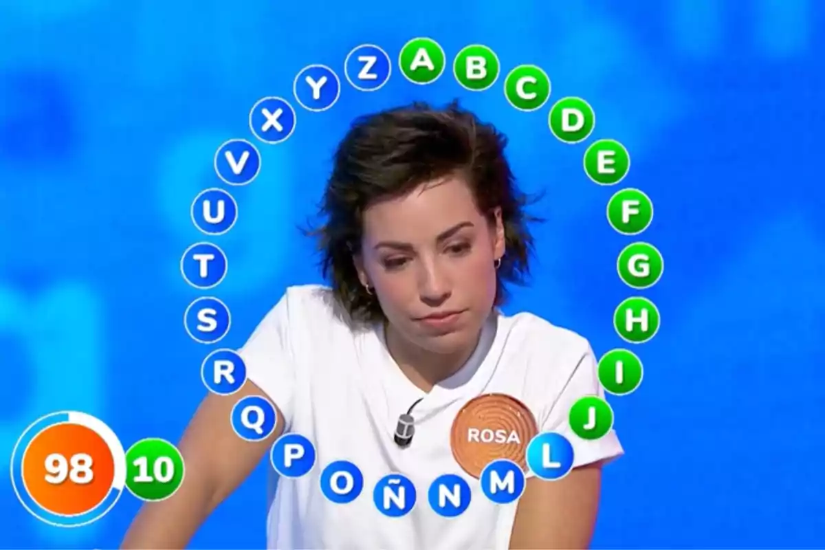 Rosa concursando en el rosco de un programa de televisión con letras alrededor y un marcador de tiempo y aciertos a la izquierda. Captura de 'Pasapalabra' Rosa concursando en el rosco de un programa de televisión con letras alrededor y un marcador de tiempo y aciertos a la izquierda. Captura de 'Pasapalabra'