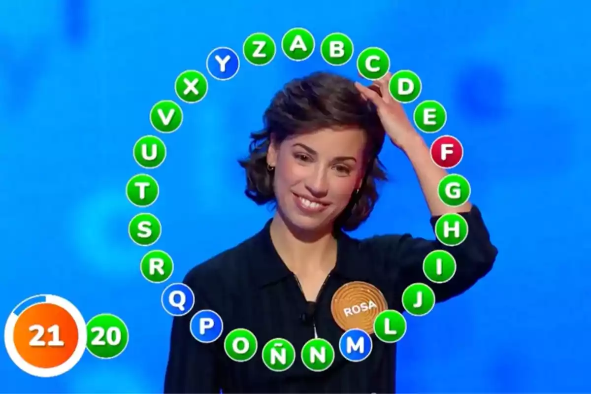 Rosa sonríe mientras participa en un concurso de televisión con un panel de letras en forma de círculo a su alrededor. Captura de 'Pasapalabra' Rosa sonríe mientras participa en un concurso de televisión con un panel de letras en forma de círculo a su alrededor. Captura de 'Pasapalabra'