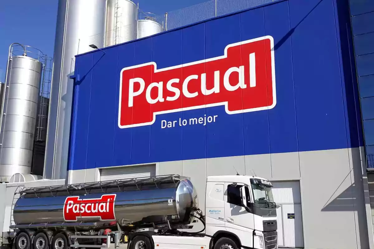 Un camión cisterna con el logotipo de Pascual estacionado frente a un edificio industrial con un gran cartel de la misma marca.