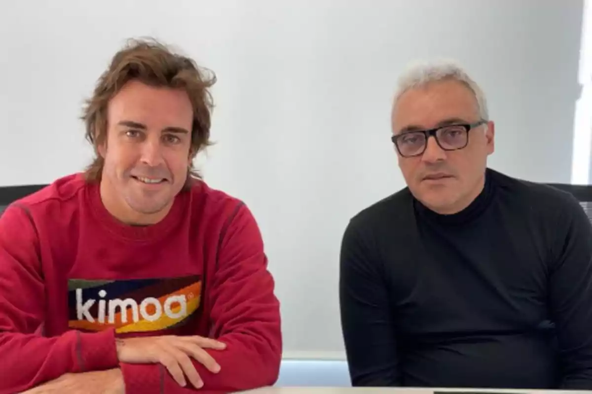 Dos personas sentadas en una mesa una con suéter rojo y la otra con suéter negro. Dos personas sentadas en una mesa una con suéter rojo y la otra con suéter negro.