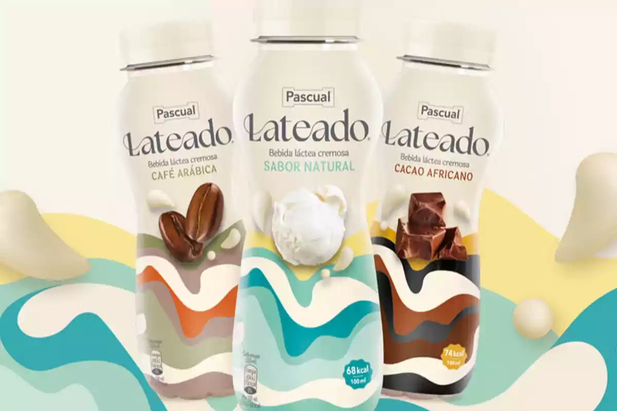 Tres botellas de bebida láctea cremosa de la marca Pascual con sabores café arábica, sabor natural y cacao africano sobre un fondo colorido.
