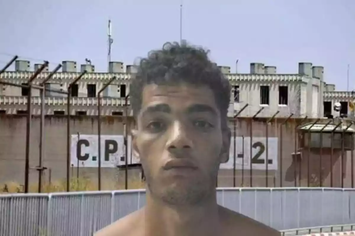 Hombre frente a una prisión con las letras 