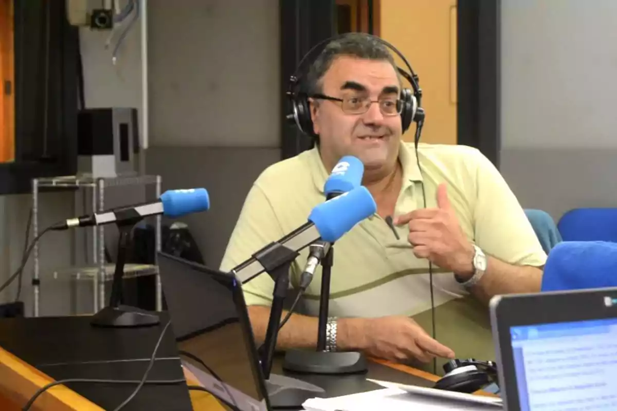 Un hombre con audífonos y micrófono en un estudio de radio, haciendo un gesto con la mano. Un hombre con audífonos y micrófono en un estudio de radio, haciendo un gesto con la mano.