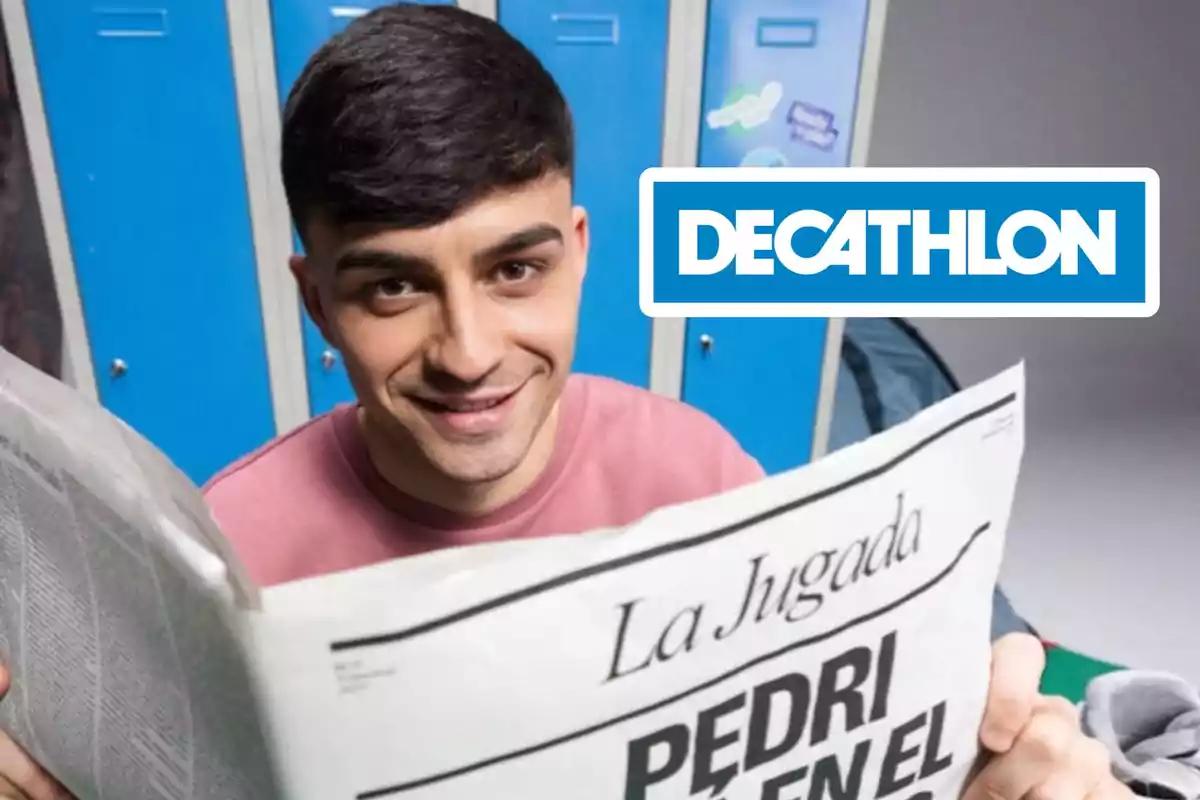 Un joven sonriente sostiene un periódico frente a unos casilleros azules con el logo de Decathlon en la parte superior derecha.