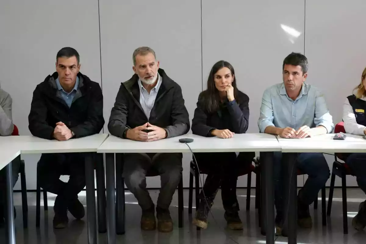 Pedro Sánchez, Felipe VI, Letizia y Carlos Mazón sentadas en una mesa durante una reunión.