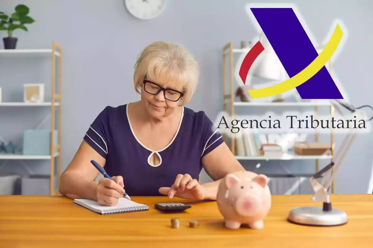 Una mujer mayor realiza cuentas con una calculadora y el logo de la Agencia Tributaria