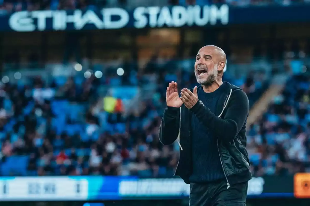 Un entrenador de fútbol gesticula en la línea lateral del campo durante un partido en un estadio lleno de espectadores. Un entrenador de fútbol gesticula en la línea lateral del campo durante un partido en un estadio lleno de espectadores.