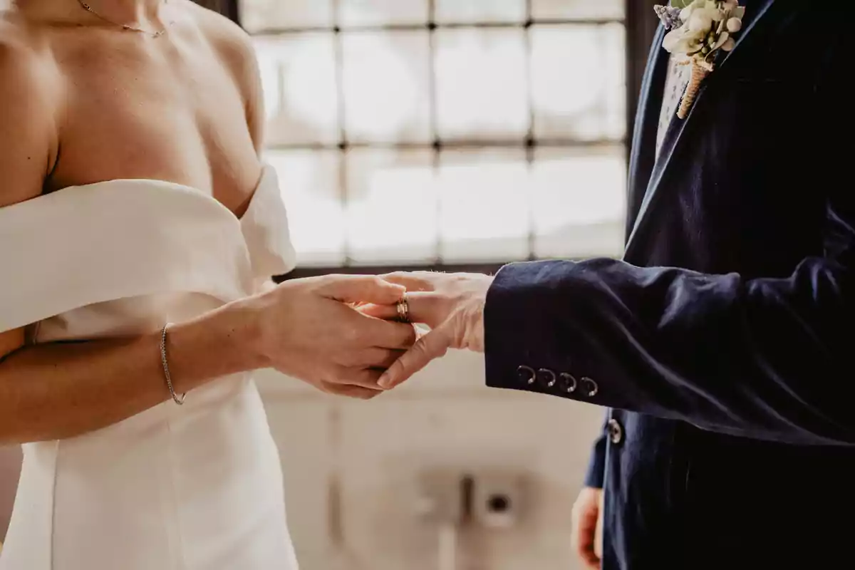 Pareja intercambiando anillos durante una ceremonia de boda.