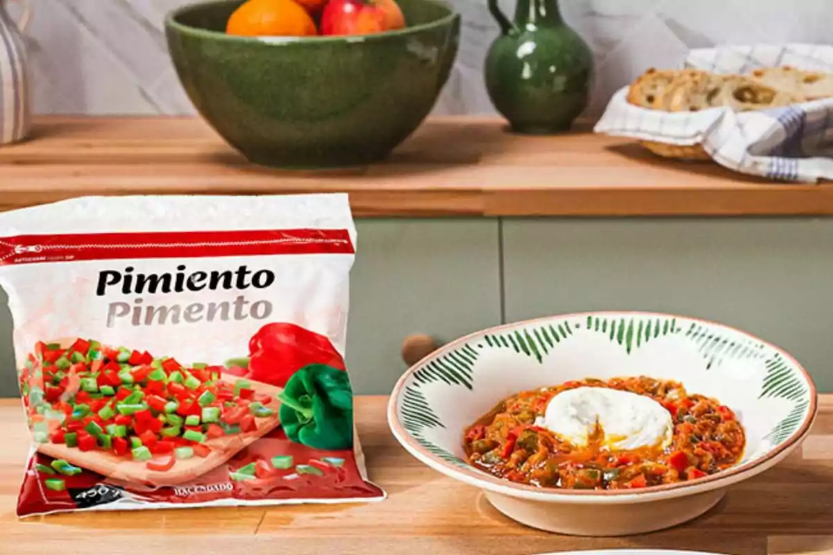 Un paquete de pimientos picados junto a un plato de comida con pimientos y un huevo poché en una cocina con frutas y pan al fondo. Un paquete de pimientos picados junto a un plato de comida con pimientos y un huevo poché en una cocina con frutas y pan al fondo.