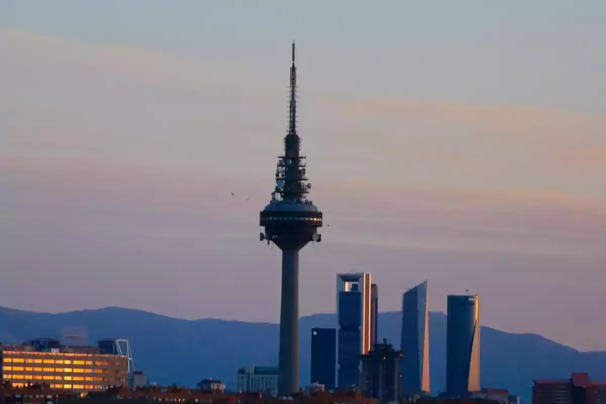 Vista de la ciudad de Madrid al atardecer con la silueta de la torre de telecomunicaciones y los rascacielos al fondo Vista de la ciudad de Madrid al atardecer con la silueta de la torre de telecomunicaciones y los rascacielos al fondo