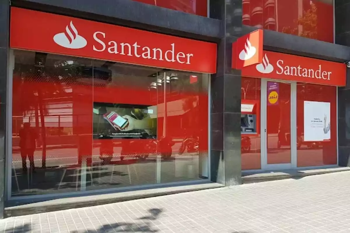 Fachada de una sucursal del banco Santander con letreros rojos y blancos.