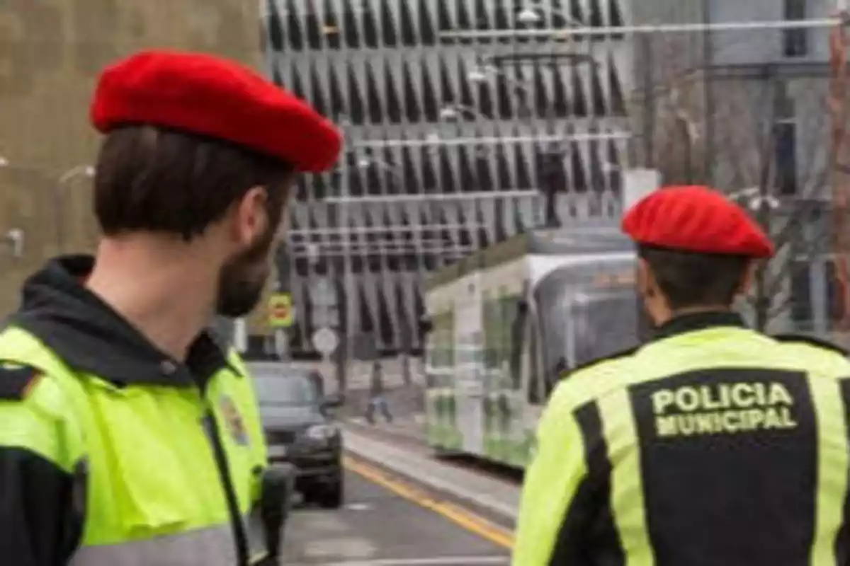 Dos policías municipales con boinas rojas observan un tranvía en una calle urbana.