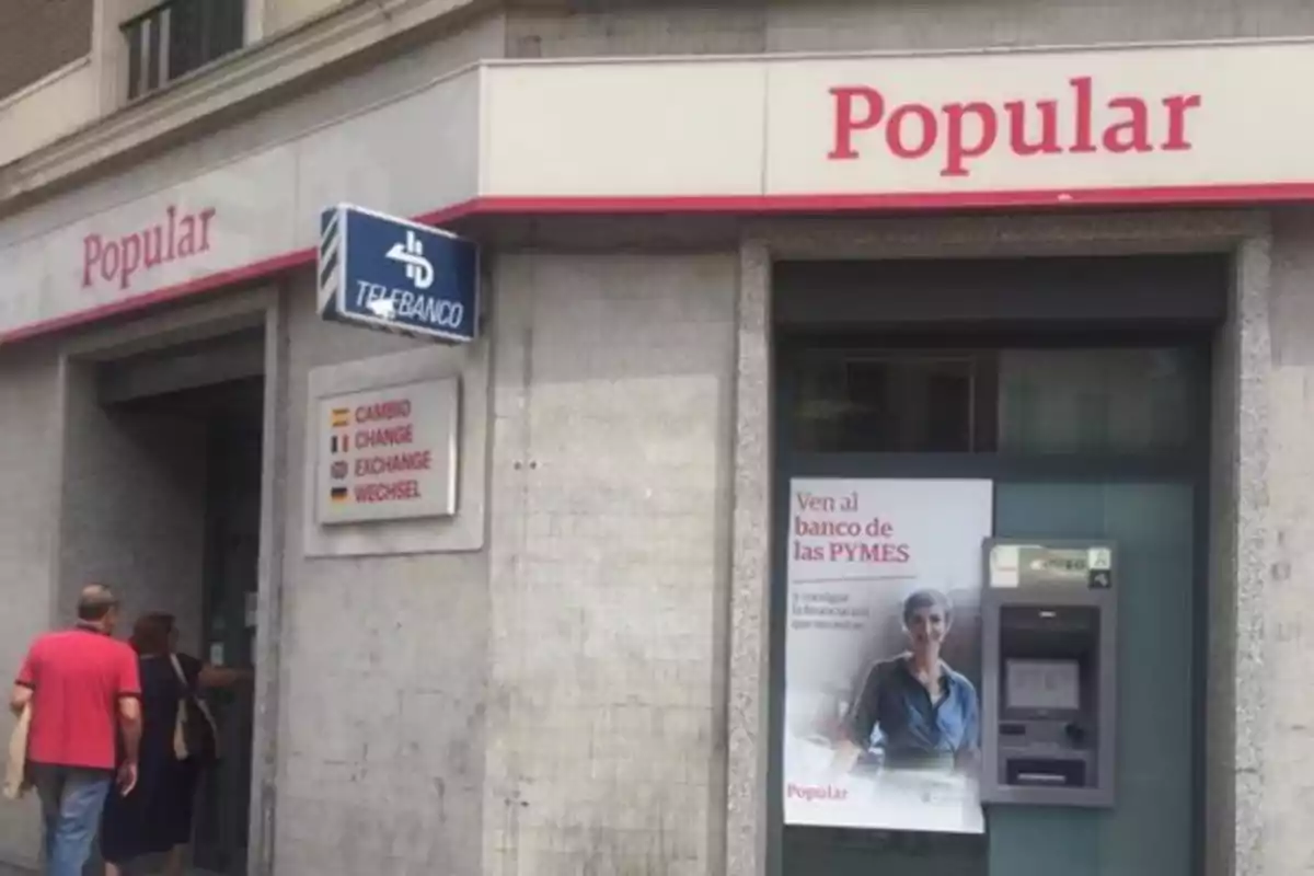 Fachada de una sucursal del Banco Popular con un cajero automático y un cartel promocional.