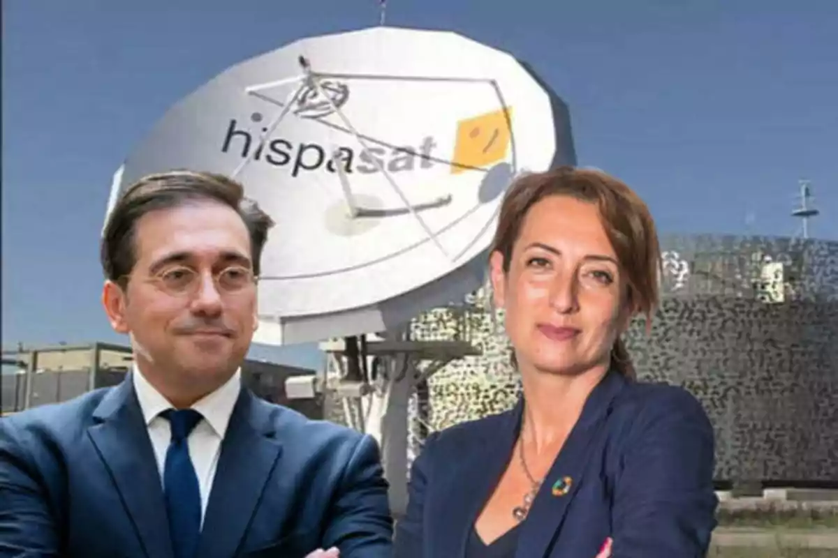 Dos personas posando frente a una antena parabólica con el logo de Hispasat.