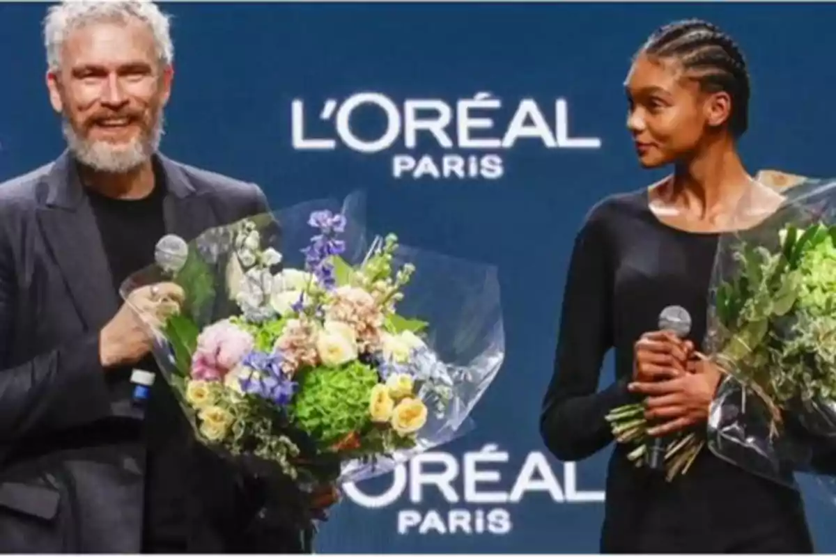 Dos personas sosteniendo ramos de flores y micrófonos en un evento de L'Oréal Paris.