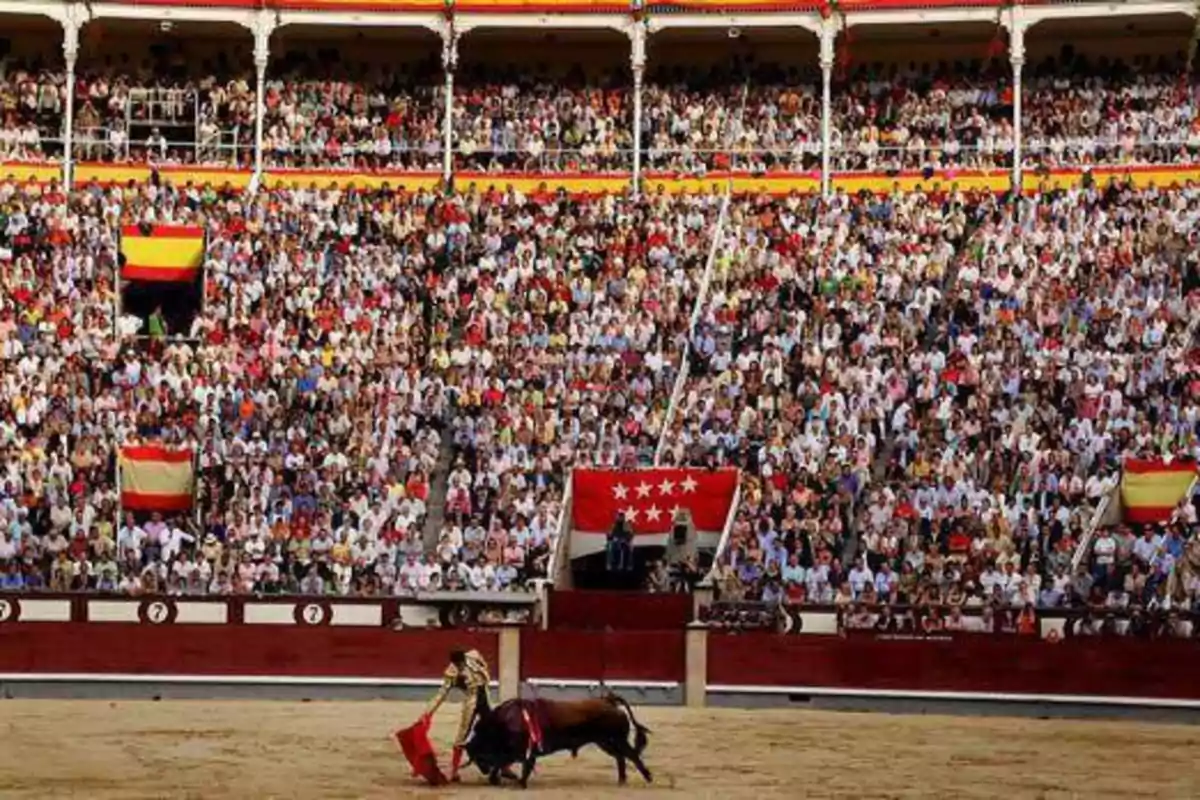 Una plaza de toros llena de espectadores observando una corrida de toros.
