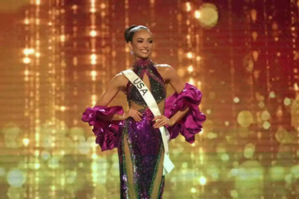 Concursante de belleza de Estados Unidos con un vestido brillante púrpura y detalles en verde, posando en un escenario iluminado con luces doradas.