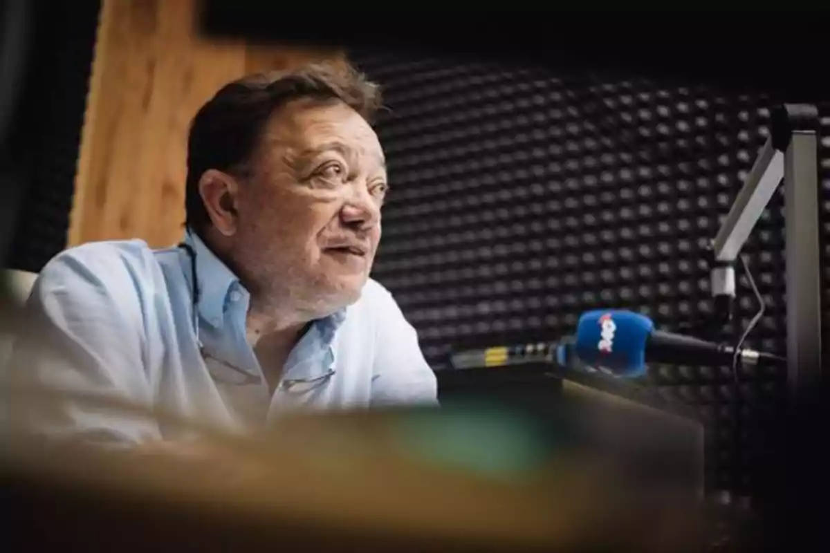 Hombre hablando en un micrófono en un estudio de grabación.