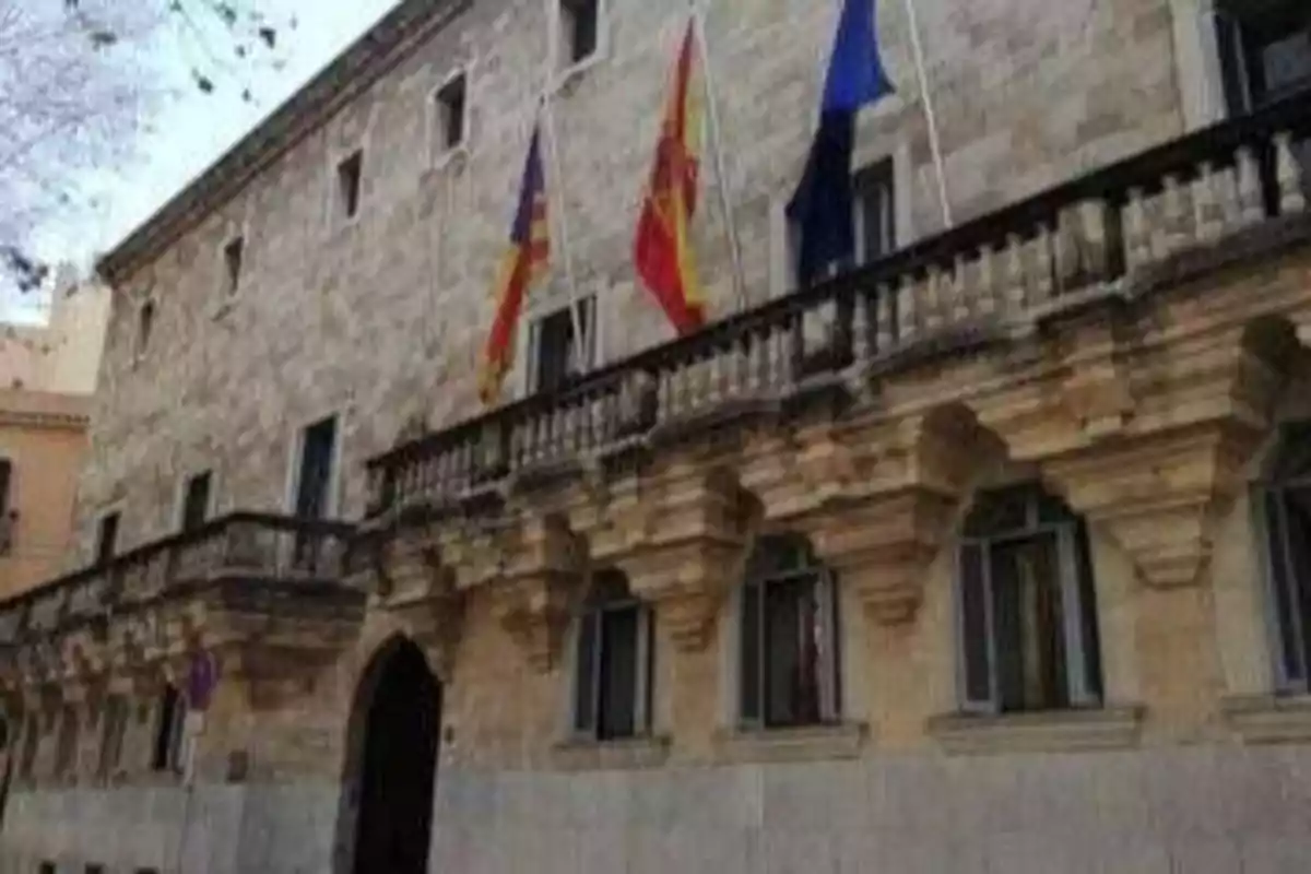 Edificio histórico con banderas en la fachada.