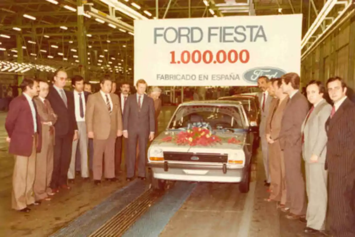 Un grupo de personas posa junto a un automóvil Ford Fiesta en una fábrica, con un cartel que celebra la producción del vehículo número 1.000.000 fabricado en España.