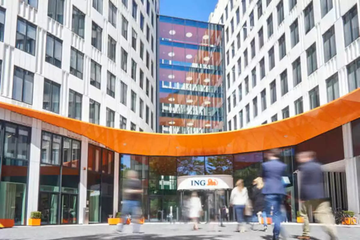 Edificio de oficinas con un letrero de ING y personas caminando en la entrada.