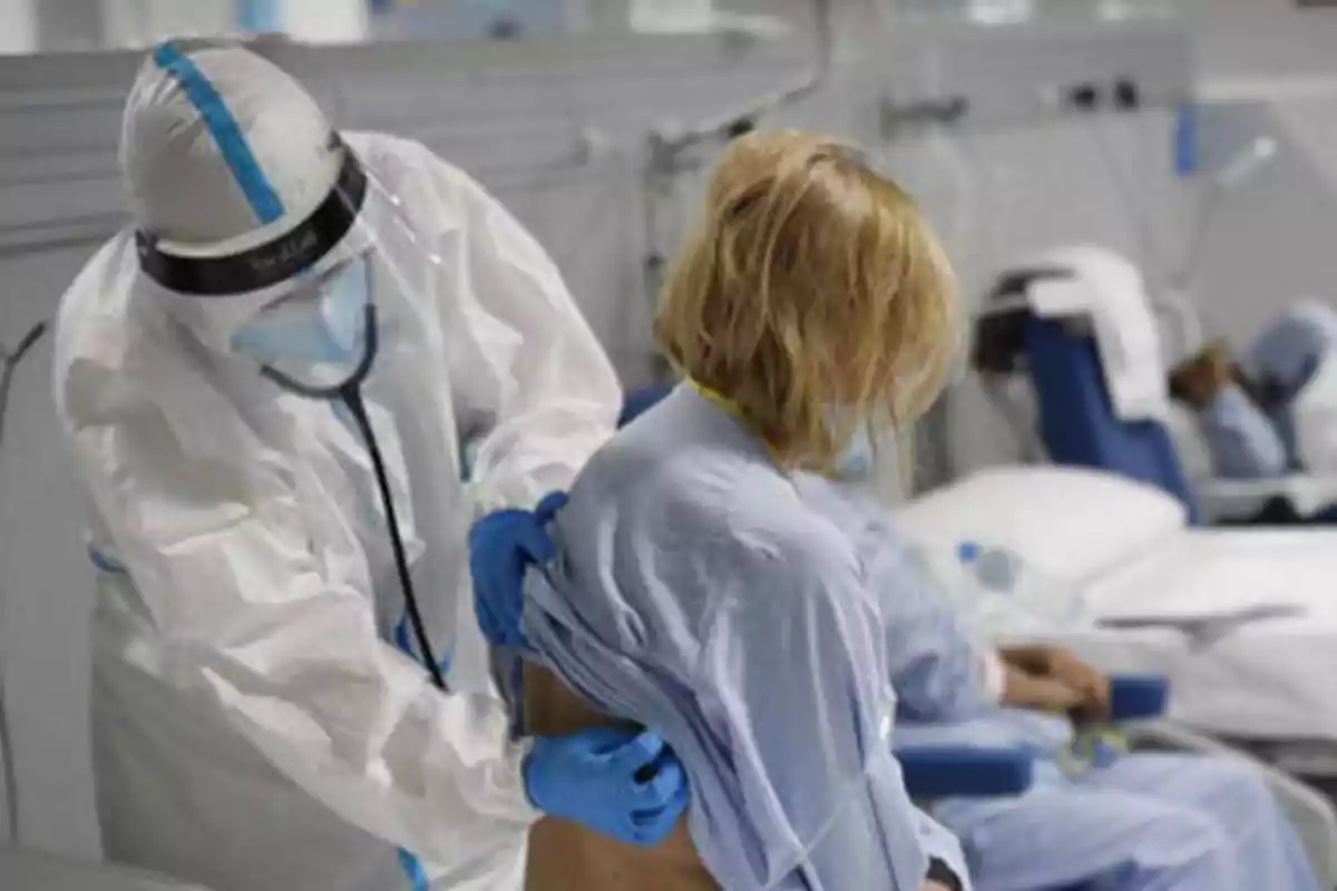 Personal médico con equipo de protección atendiendo a un paciente en un hospital.