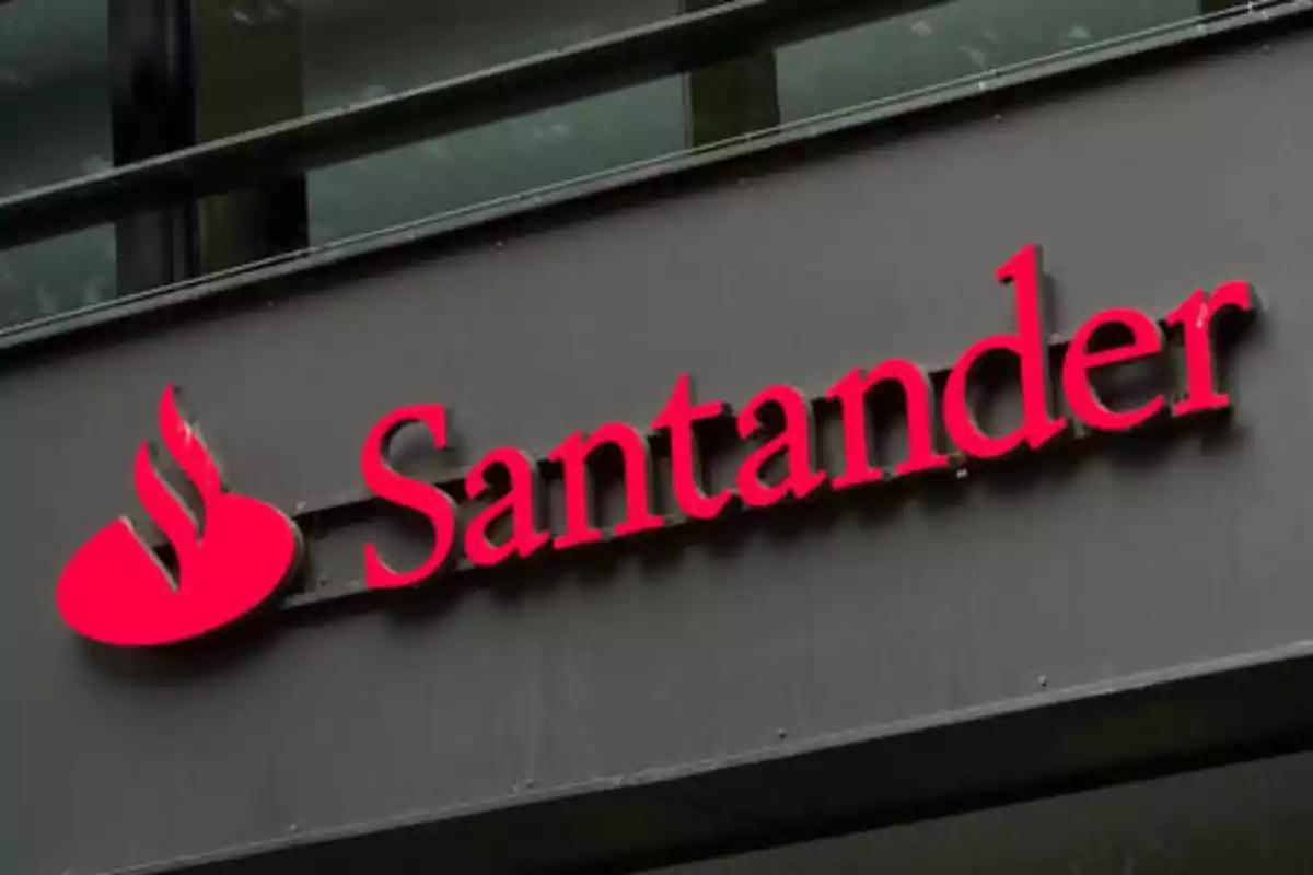 Letrero del banco Santander en una fachada gris.