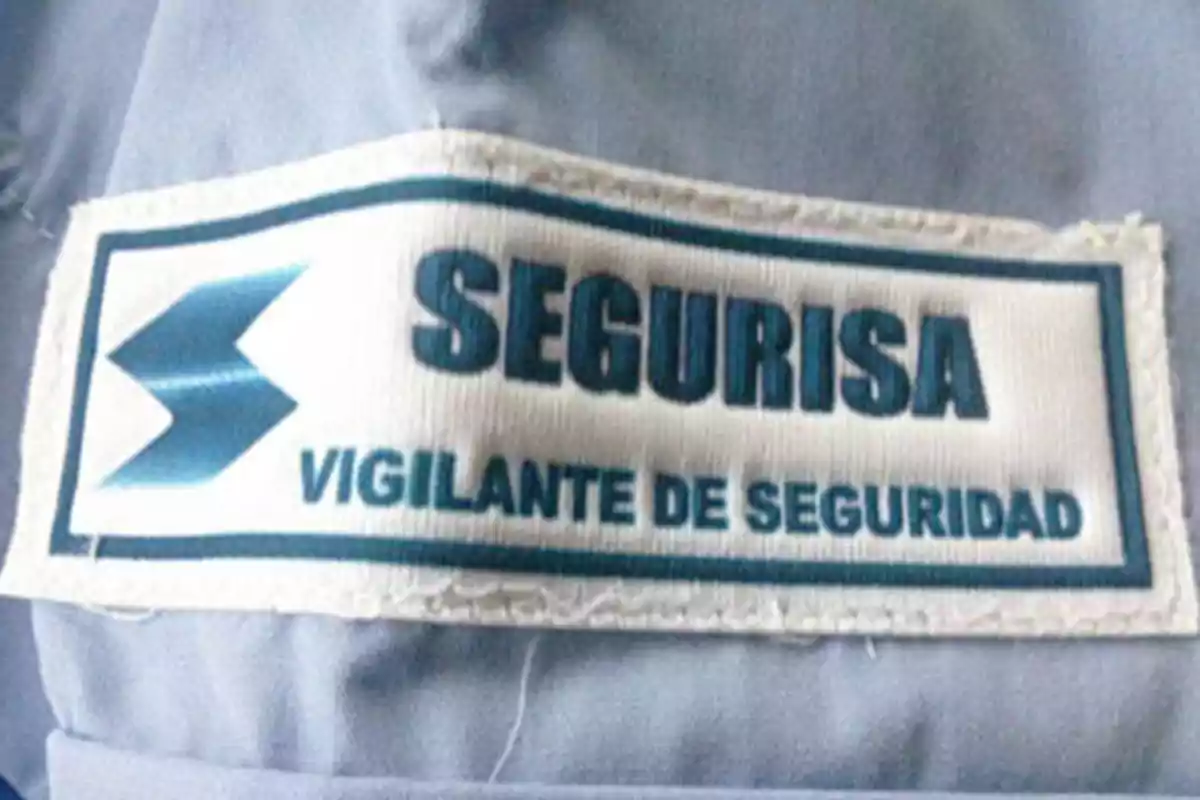 Etiqueta de uniforme con el texto "SEGURISA VIGILANTE DE SEGURIDAD".