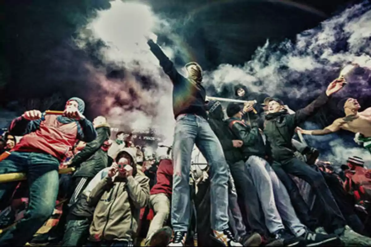 Un grupo de personas en una manifestación nocturna con bengalas y humo.