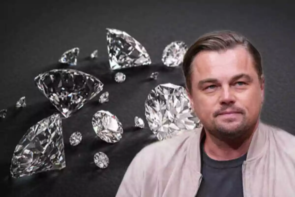 Un hombre con chaqueta clara frente a un fondo de diamantes.