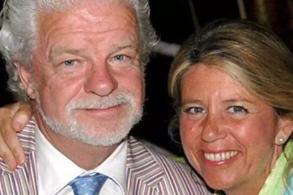 Una pareja sonriente, con el hombre de cabello canoso y barba, y la mujer de cabello rubio, posando juntos.