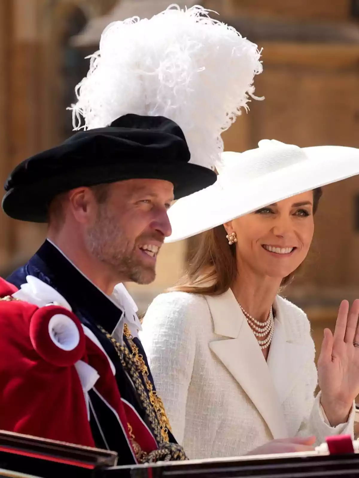 El príncipe Guillermo y Kate Middleton elegantemente vestidas participan en un evento formal al aire libre, una de ellas lleva un sombrero blanco grande y la otra un sombrero negro con plumas blancas El príncipe Guillermo y Kate Middleton elegantemente vestidas participan en un evento formal al aire libre, una de ellas lleva un sombrero blanco grande y la otra un sombrero negro con plumas blancas