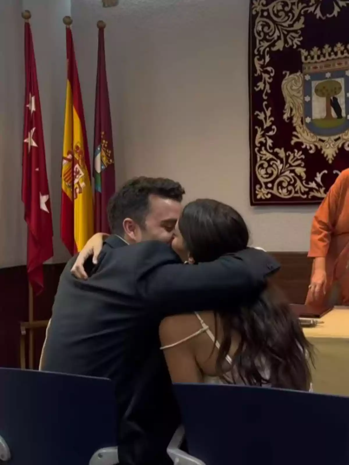 Guille Valle y Susana Molina se abraza y se besa sentada en una sala con banderas y un tapiz decorativo al fondo Guille Valle y Susana Molina se abraza y se besa sentada en una sala con banderas y un tapiz decorativo al fondo