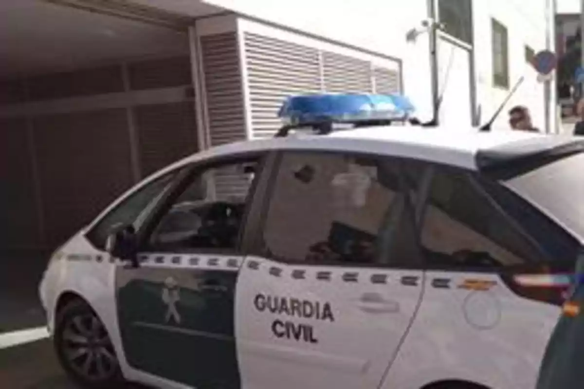 Coche de la Guardia Civil estacionado frente a un edificio.