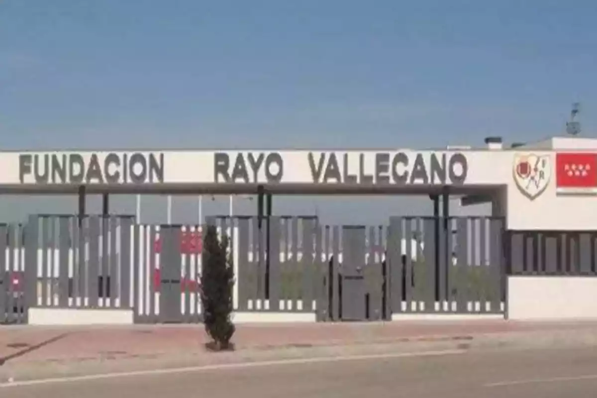 Entrada de la Fundación Rayo Vallecano con un cartel grande y escudos en la parte superior.