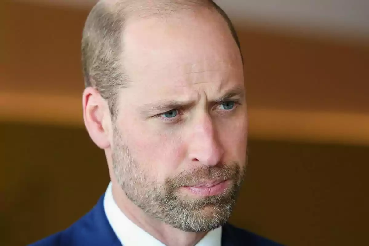 Close-up of Prince William with a serious face and a blue suit.